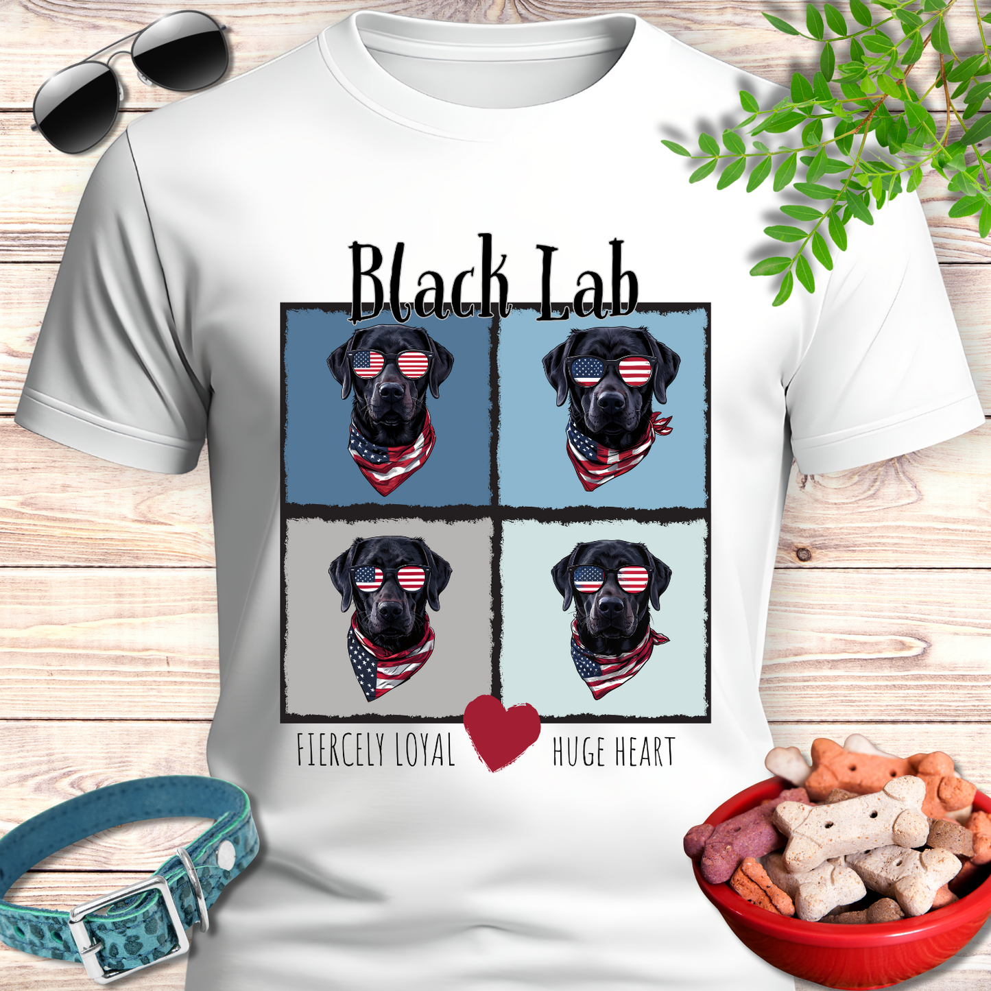 White t-shirt with black lab design and pet accessories on a wooden surface