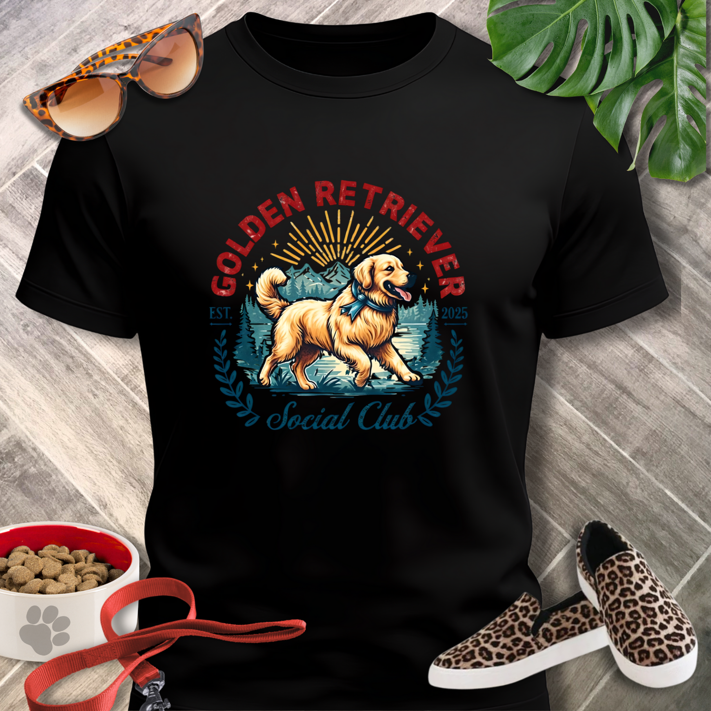 Black t-shirt with a Golden Retriever graphic and accessories on a wooden surface.