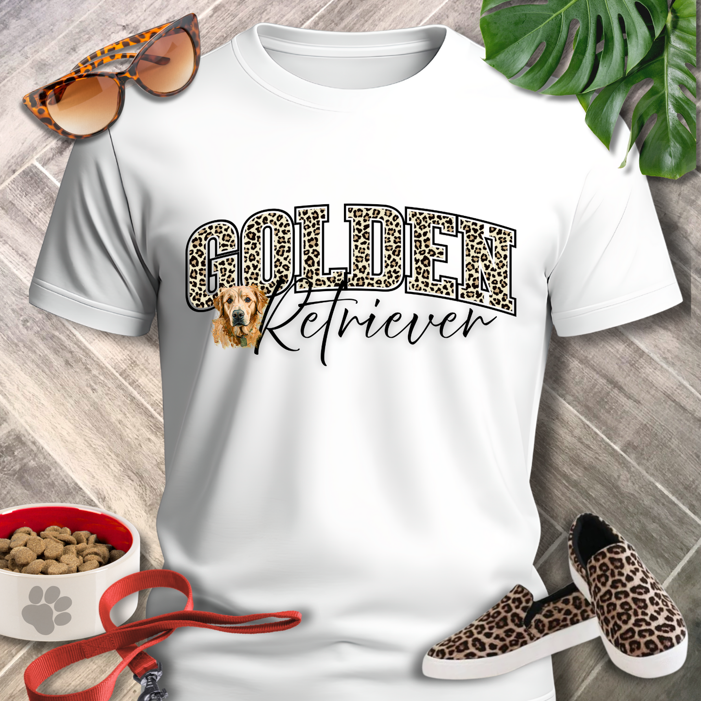 White t-shirt with 'Golden Retriever' design, leopard print shoes, and accessories on a wooden surface.