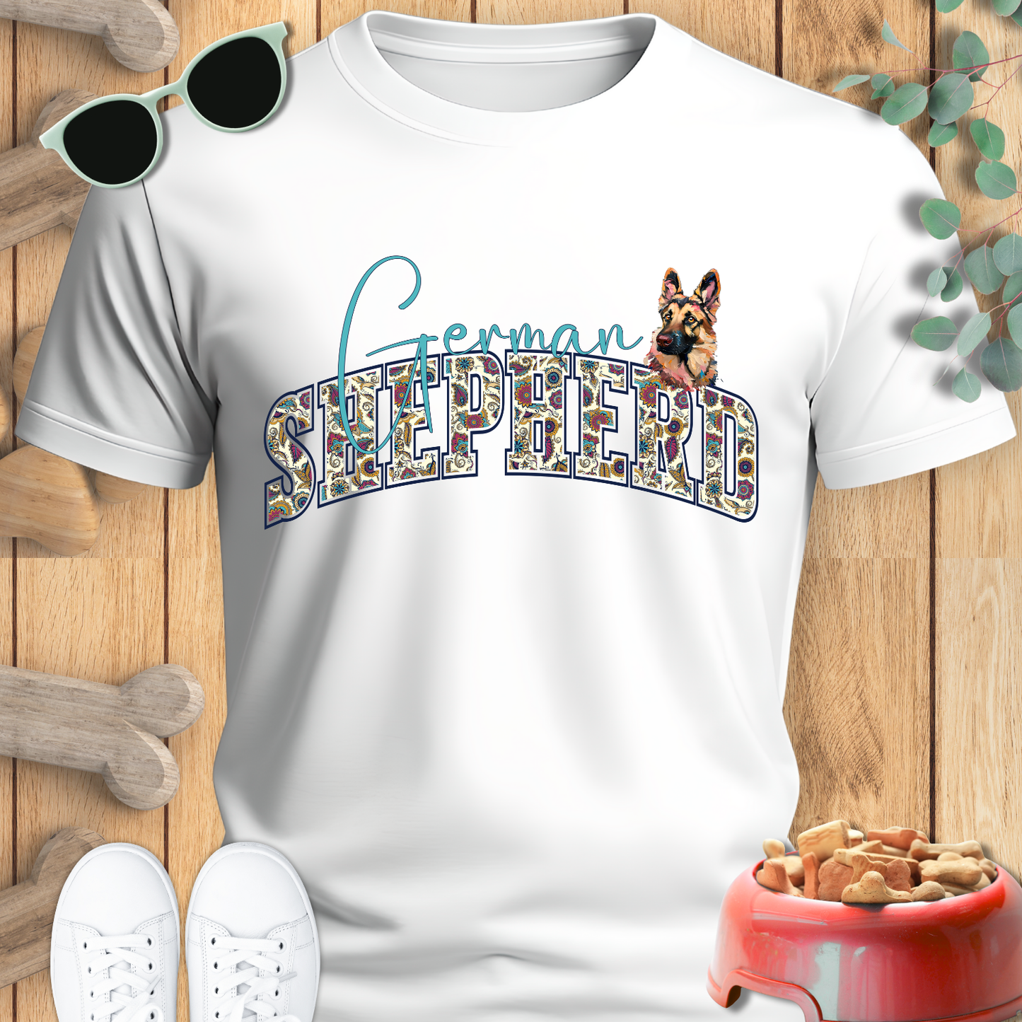 White t-shirt with 'German Shepherd' design on a wooden surface with accessories.