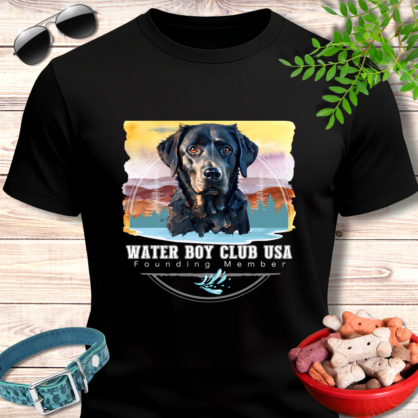 Black t-shirt with a dog graphic and 'Water Boy Club USA' text on a wooden surface with accessories.