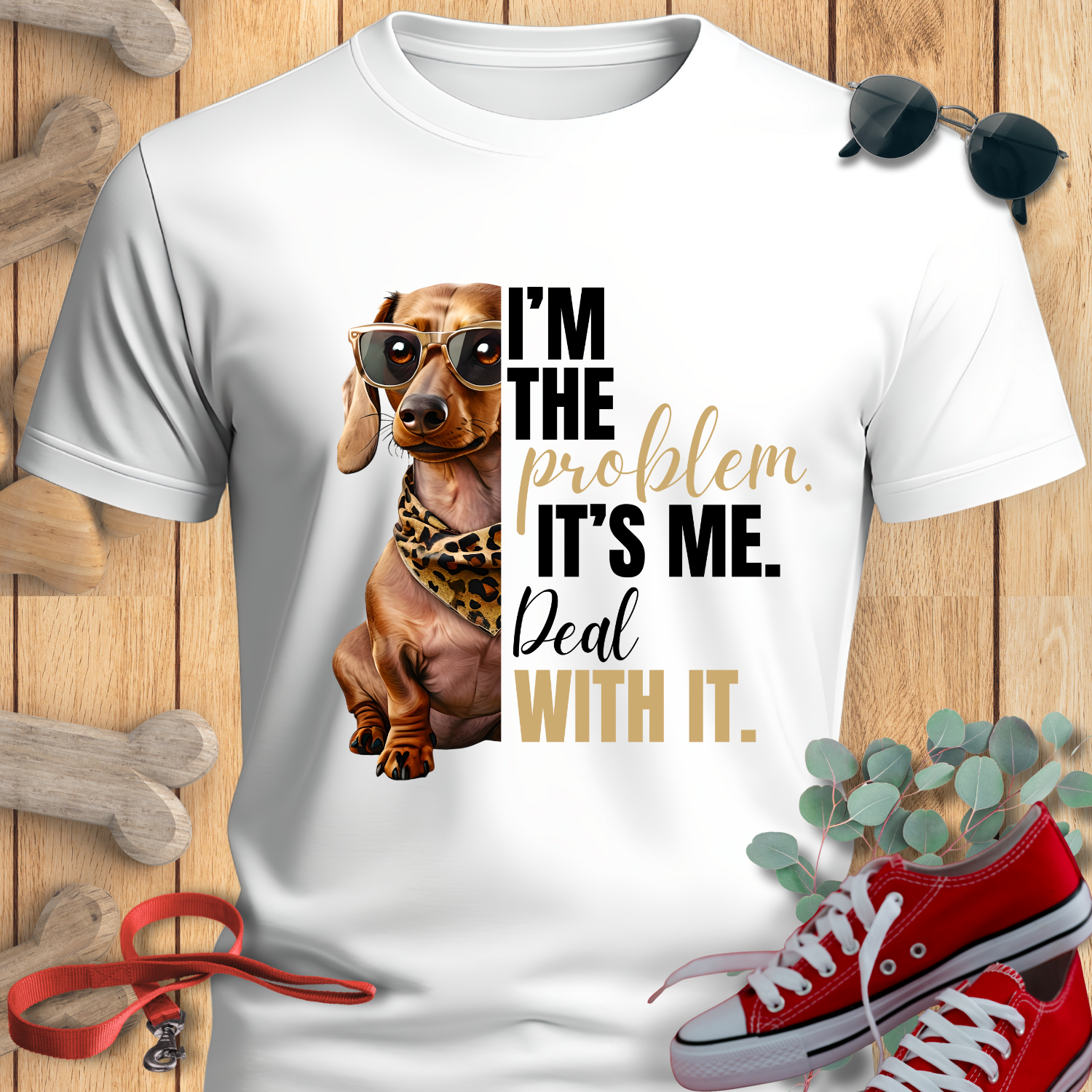 Dachshund Shirt "I'm The Problem" in White with a dachshund graphic and text on a wooden surface with shoes and a plant.