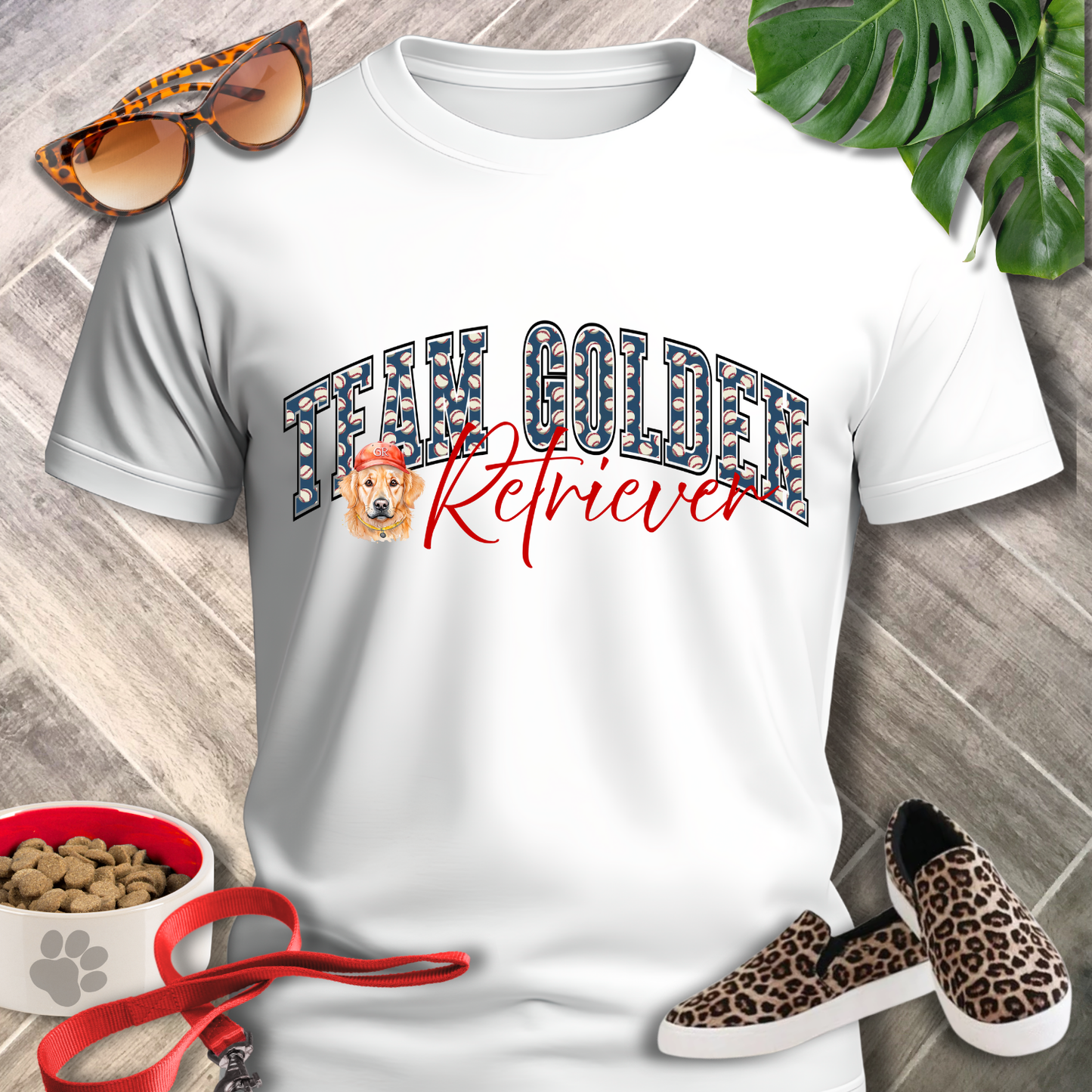 White t-shirt with 'Team Golden Retriever' design, leopard print sunglasses, sneakers, and pet food bowl on a wooden surface.