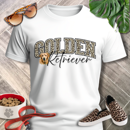 White t-shirt with 'Golden Retriever' design, leopard print shoes, and accessories on a wooden surface.