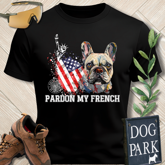 Black t-shirt with a dog graphic and 'Pardon My French' text on a wooden surface with accessories.