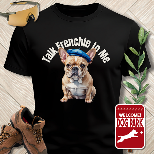 Black t-shirt with a dog graphic and text 'Talk Frenchie to Me' on a wooden floor.