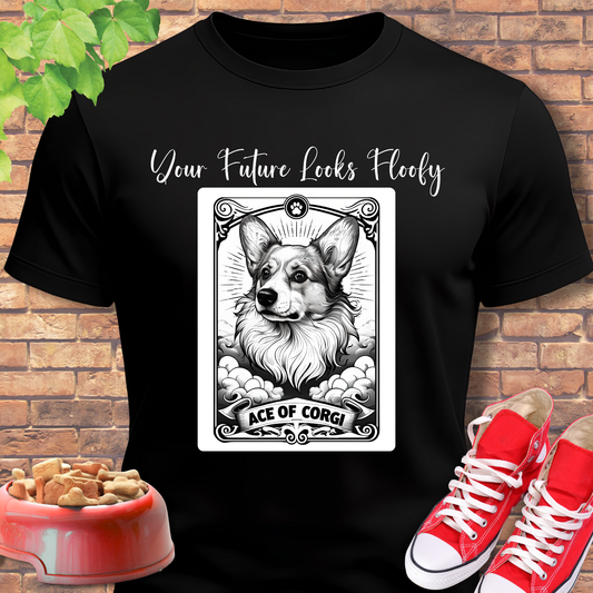 Black t-shirt with a dog illustration and text, placed against a brick wall with red shoes and a bowl of dog treats.
