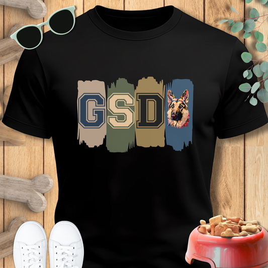Black t-shirt with 'GSD' and a German Shepherd design on a wooden surface.