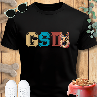 Black t-shirt with 'GSD' and a German Shepherd graphic on a wooden surface.