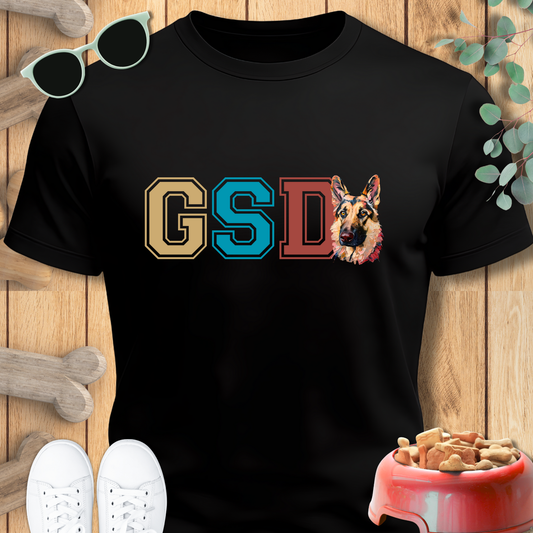Black t-shirt with 'GSD' and a German Shepherd graphic on a wooden surface.