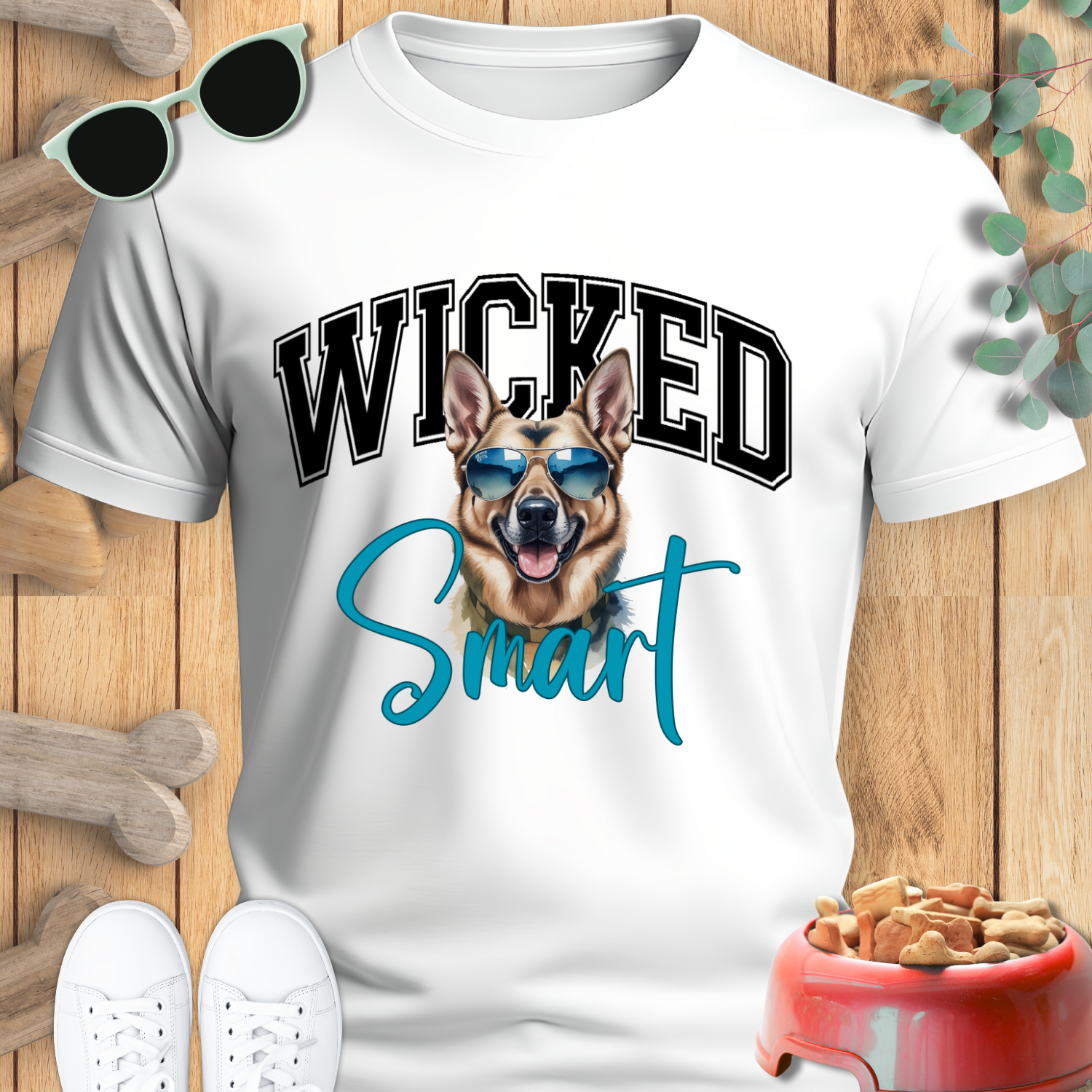 White t-shirt with a dog graphic and 'Wicked Smart' text on a wooden surface with sunglasses and a bone.