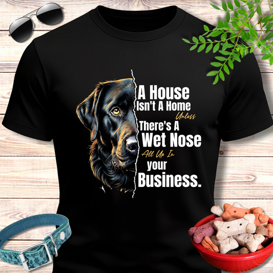 Black t-shirt with a dog graphic and text on a wooden surface with pet accessories.