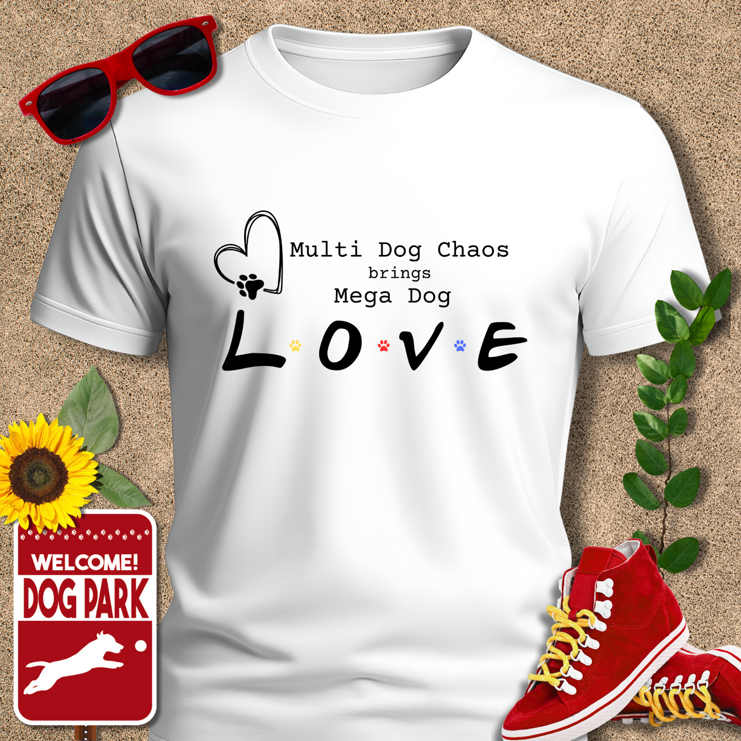 White t-shirt with 'Multi Dog Chaos brings Mega Dog LOVE' text, surrounded by sunglasses, sneakers, a sunflower, and a 'Welcome to the Dog Park' sign.