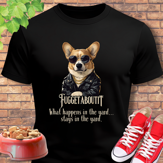 Black corgi tshirt with a dog graphic and text, placed against a brick wall background.