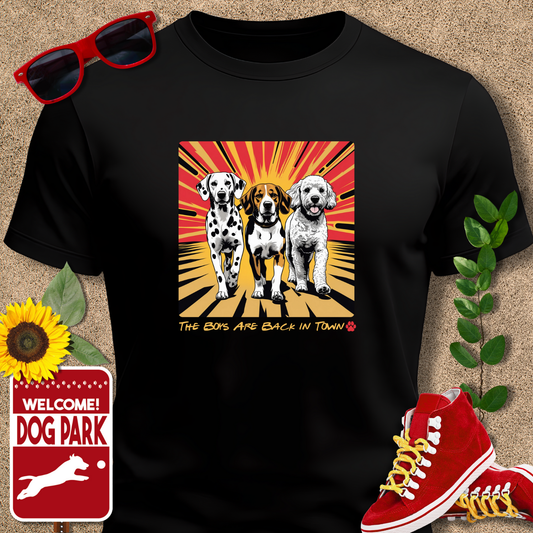 Multiple dogs Back in Town TShirt in Black with dog graphic and text, sunglasses, red sneakers, sunflower, and 'Welcome to Dog Park' sign on a textured background.
