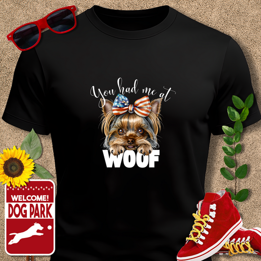 Black yorkie tshirt with a dog graphic and text, sunglasses, red sneakers, sunflower, and 'Welcome to Dog Park' sign on a beige background.
